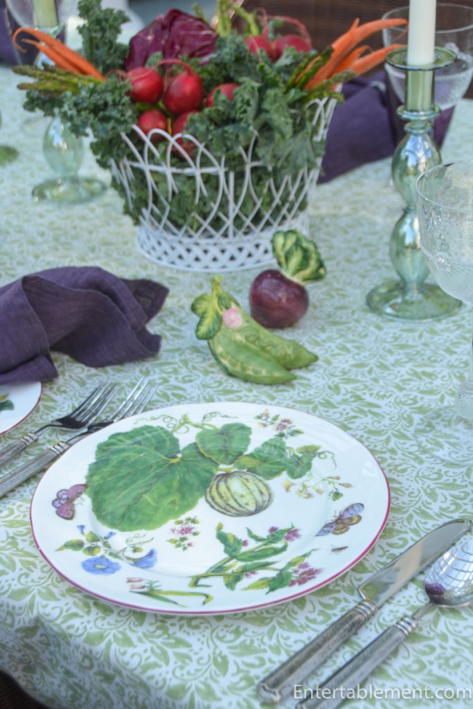 Basket filled with carrots, radishes, asparagus and kale arranged as a vegetable centerpiece on an outdoor table with Chelsea porcelain.