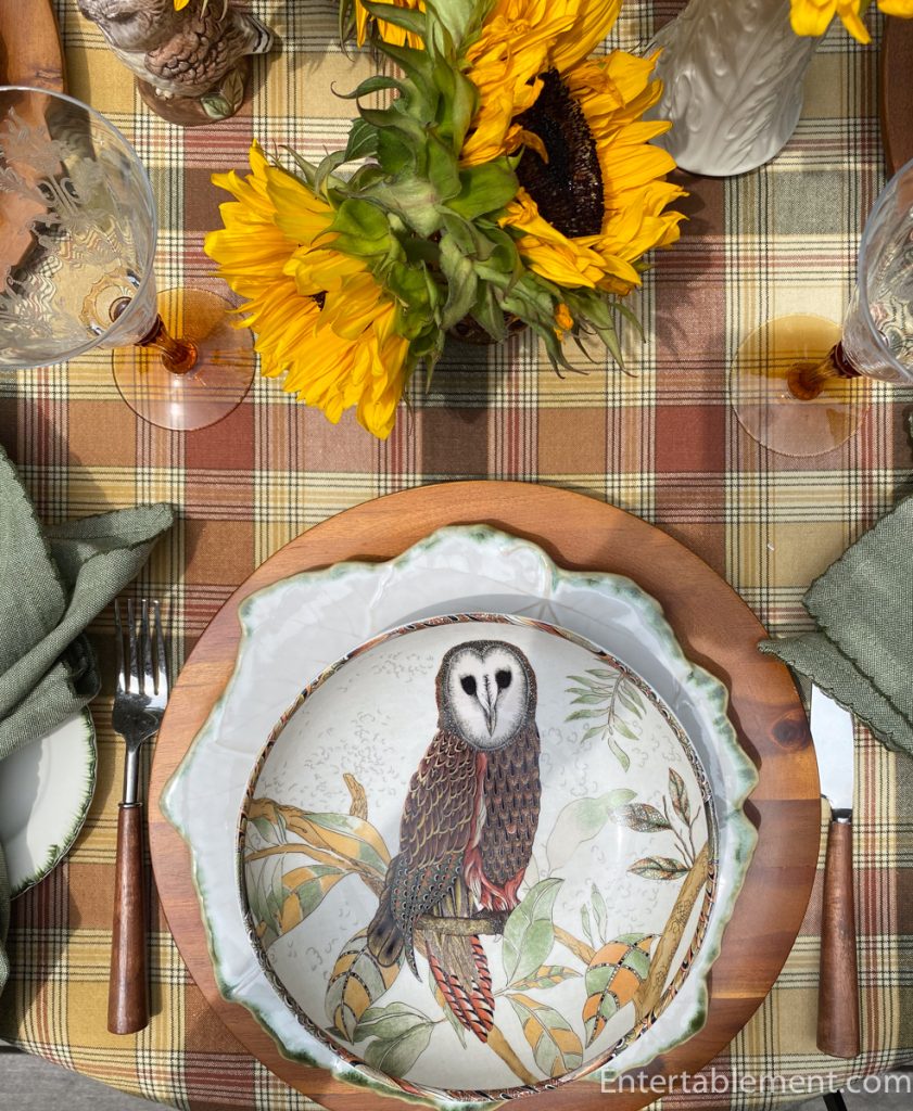 Barn owl pasta bowl at place setting with plaid tablecloth and sunflower arrangement.