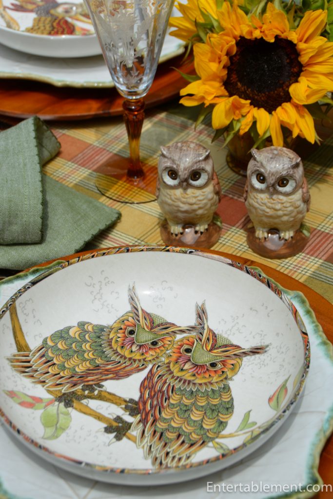 Owl-themed salt and pepper shakers beside a sunflower centrepiece and etched amber goblets.