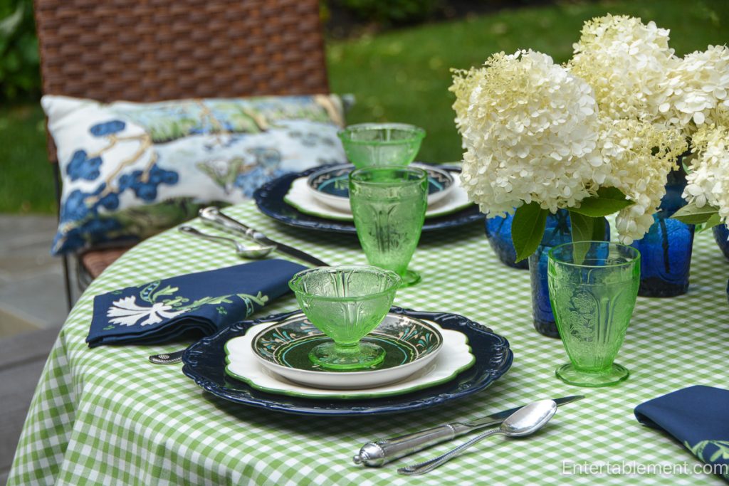 Jeanette Green Cherry Blossom Depression glass sherbets and tumblers on a gingham tablescape with navy and white china and white hydrangeas.