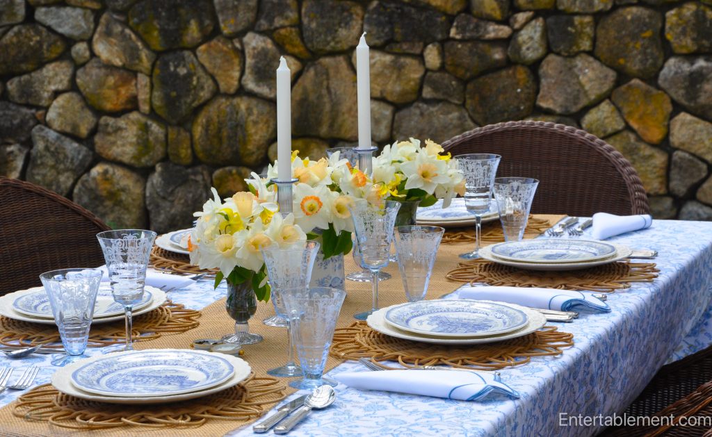 Gien de la Loire plates with images of six Châteaux, set on a spring table with rattan chargers and daffodils.