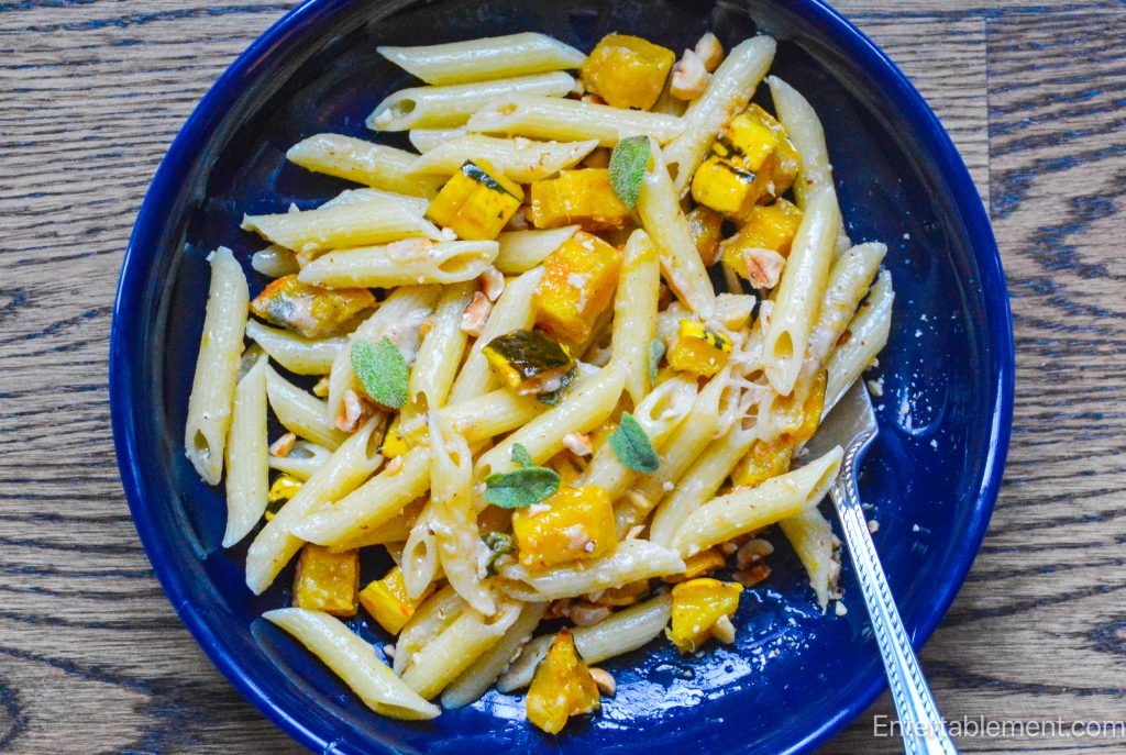 Creamy pasta with roasted delicata squash, sage and Parmesan, served in a shallow bowl.