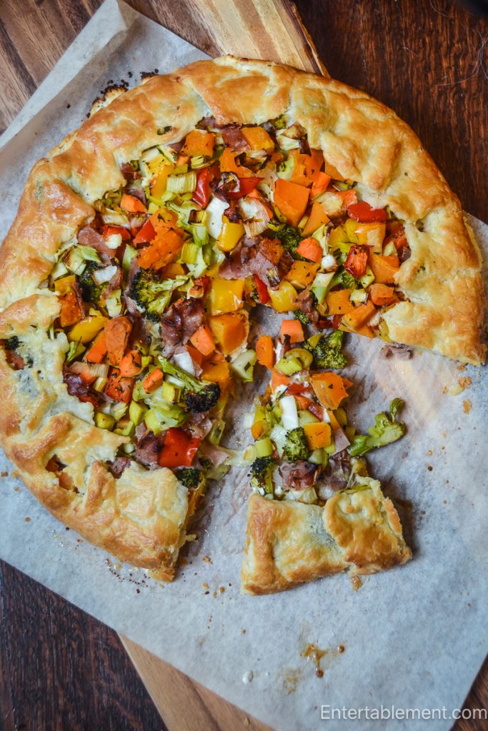 Free-form roasted vegetable and prosciutto tart with butternut squash, leeks, broccoli, and red pepper in a golden cream cheese pastry crust.