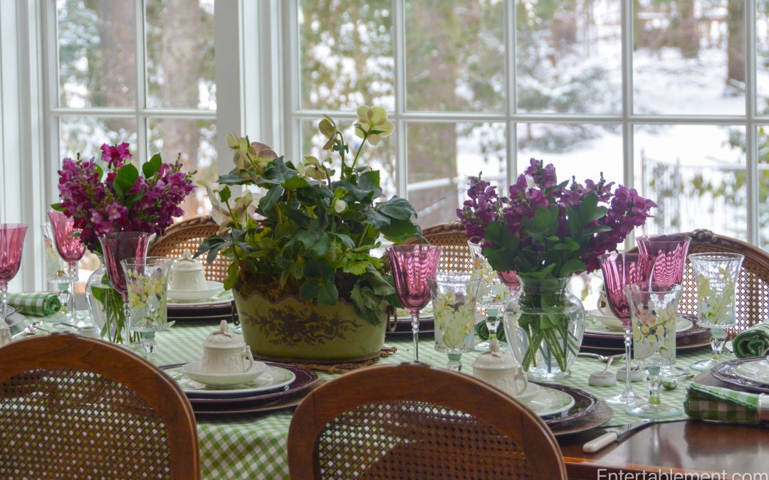Spring dining table with green gingham tablecloth, purple IKEA Arv plates, Gien Fleur de Chine salad plates, and mixed floral arrangements by the window.