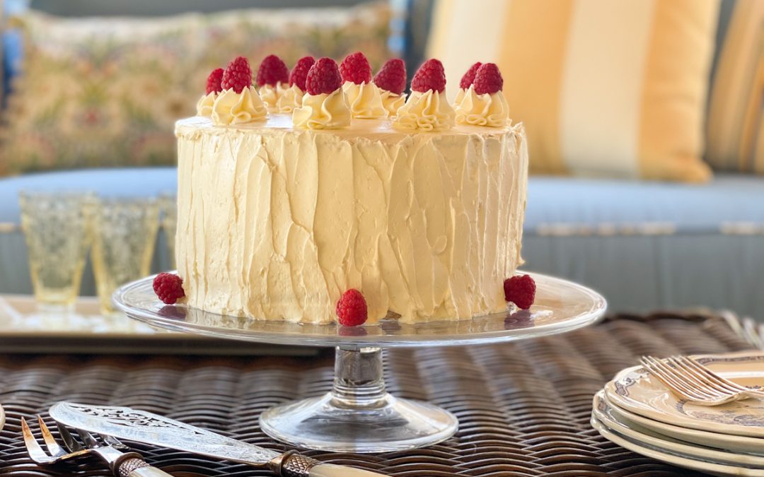 Lemon raspberry cake with fresh raspberries and whipped frosting, sliced to show layered interior