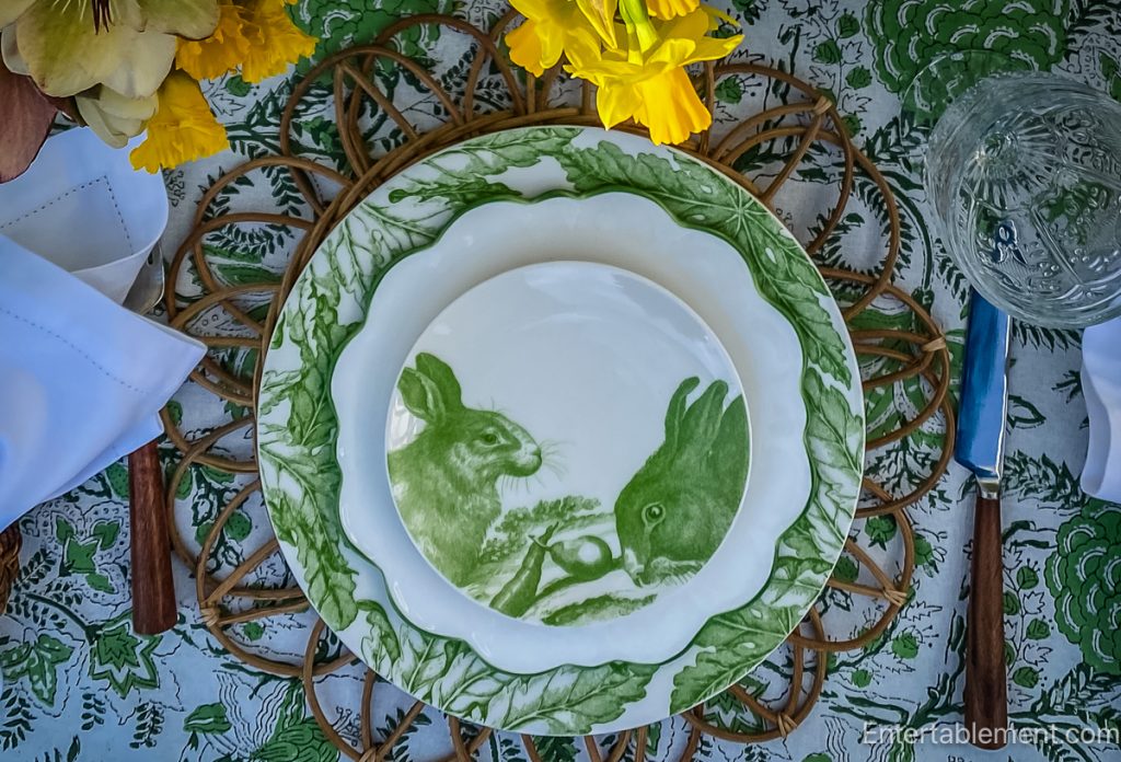 Caskata rabbit plate with two rabbits illustration on green Freya dinner plate and wicker charger
