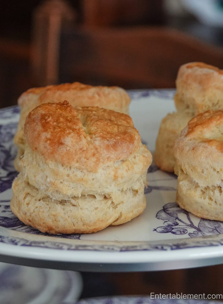 Close-up of a freshly baked Classic English tea scone showing its light, flaky layers on a blue and white transferware plate.