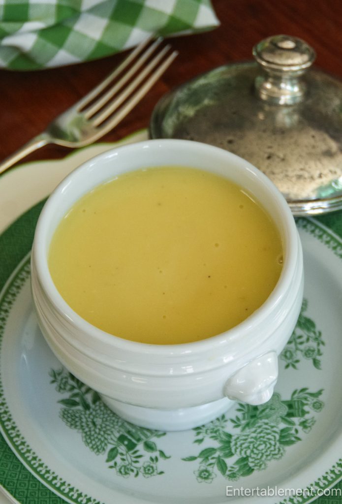 Smooth potato leek soup served in a white lion-head bowl on green transferware china.