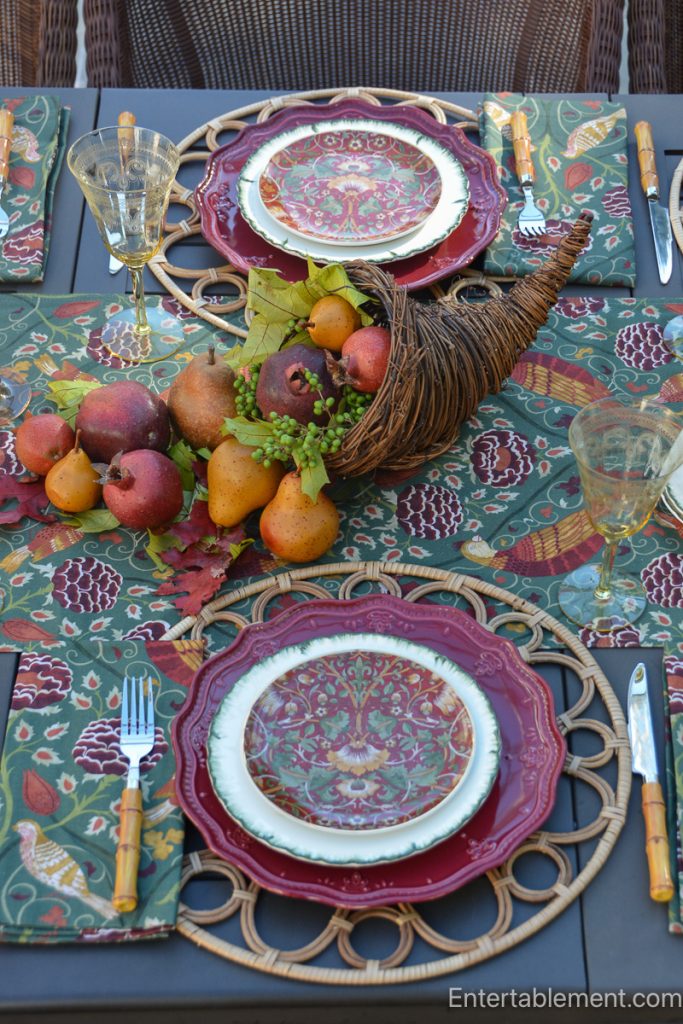Pears, pomegranates, berries and autumn leaves arranged in a wicker cornucopia