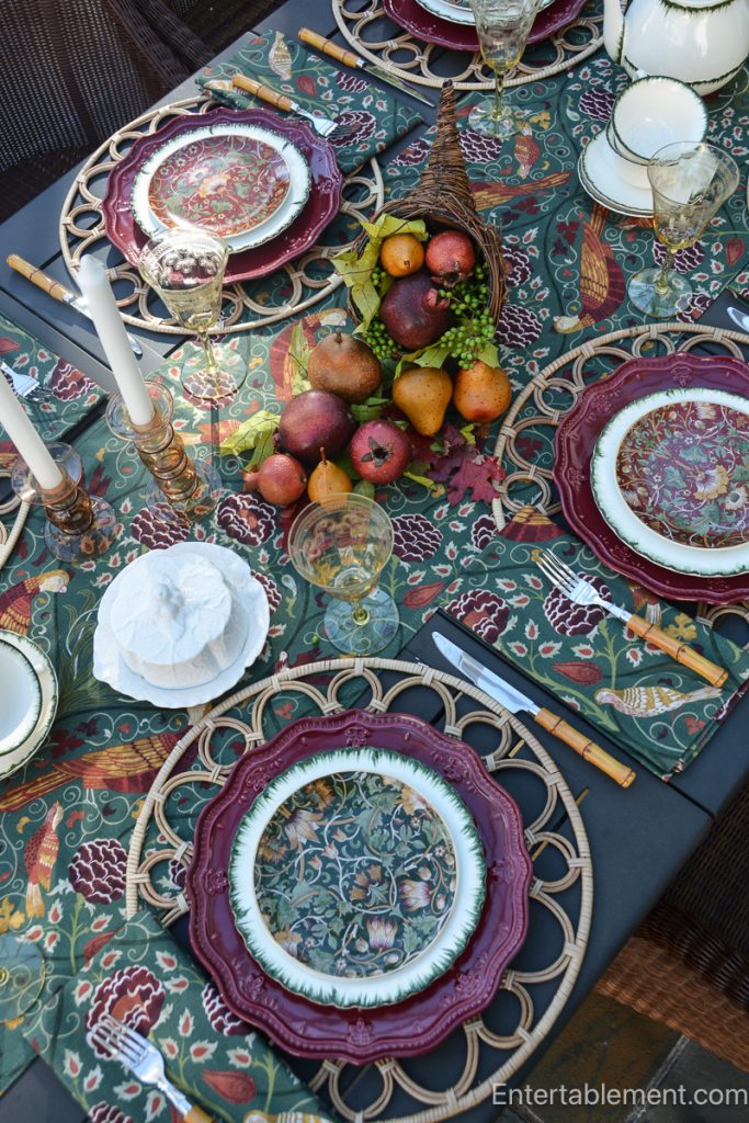 Pears, pomegranates, berries and autumn leaves arranged in a wicker cornucopia